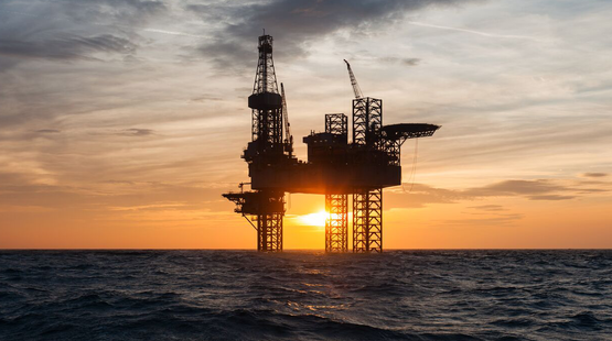 Photo of an offshore oil rig at sunset.