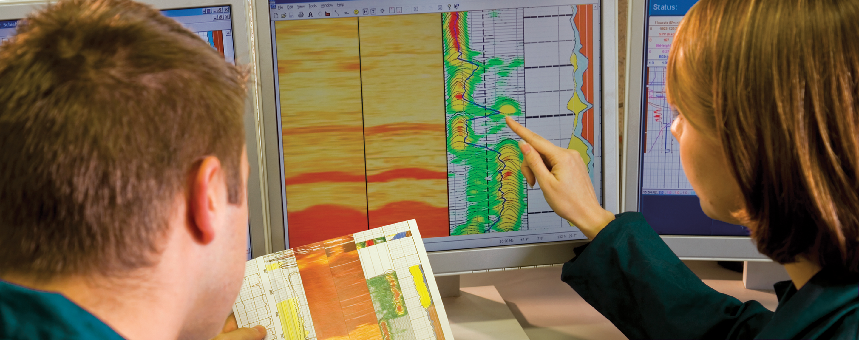 Two Baker Hughes engineers surveying a wireline log.