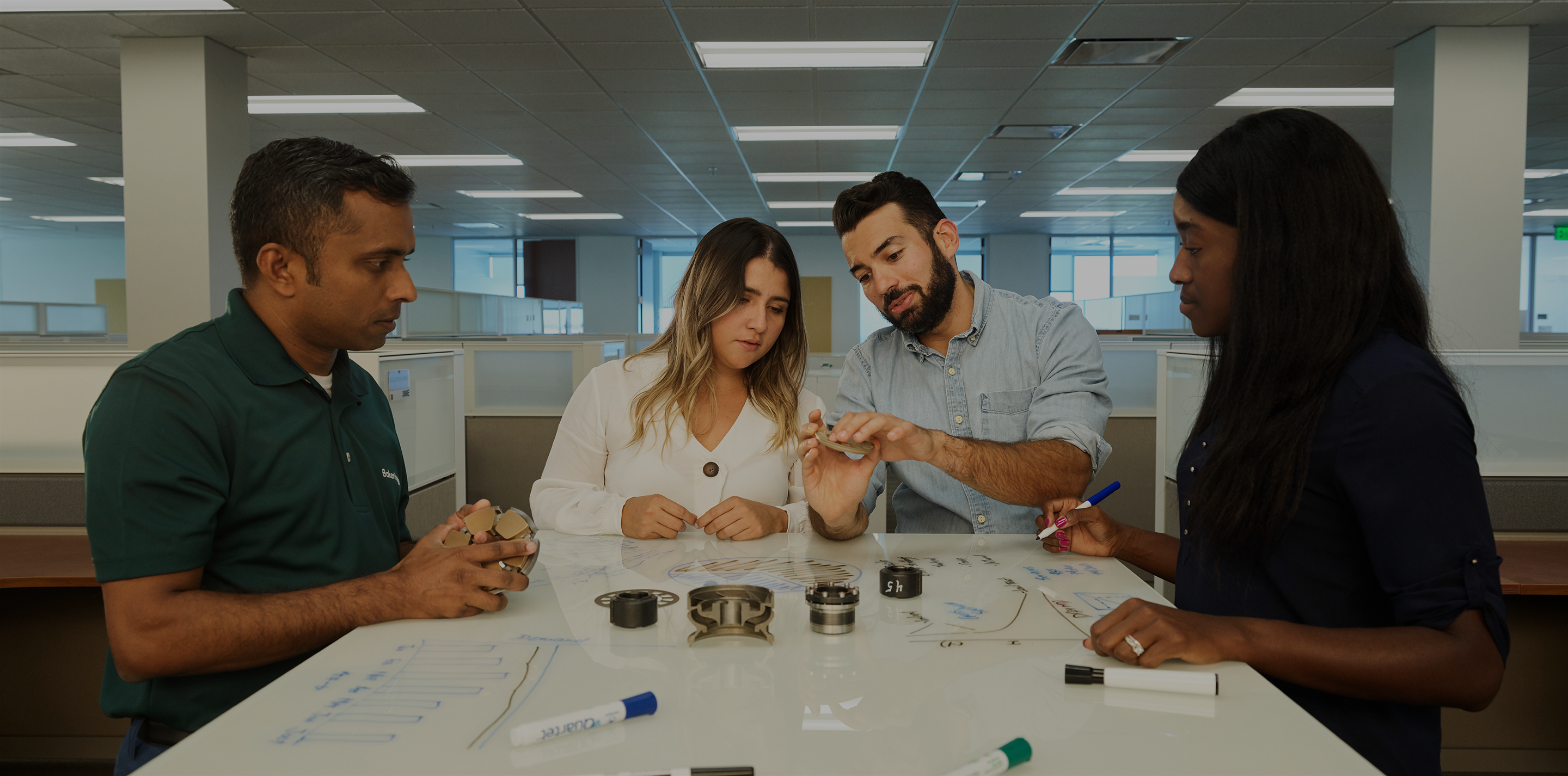 Photo of a Baker Hughes employee working with some channel partners in the office.