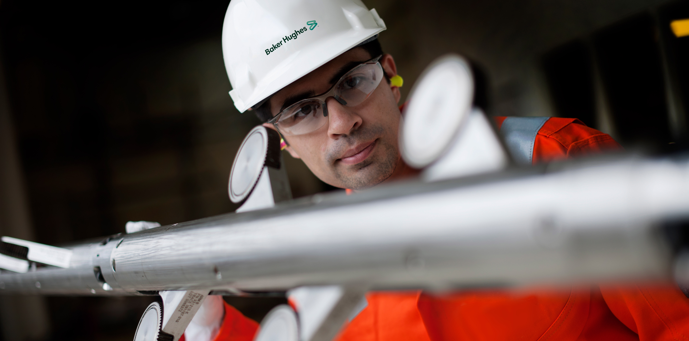 Photo of a Baker Hughes engineer inspecting a tool.