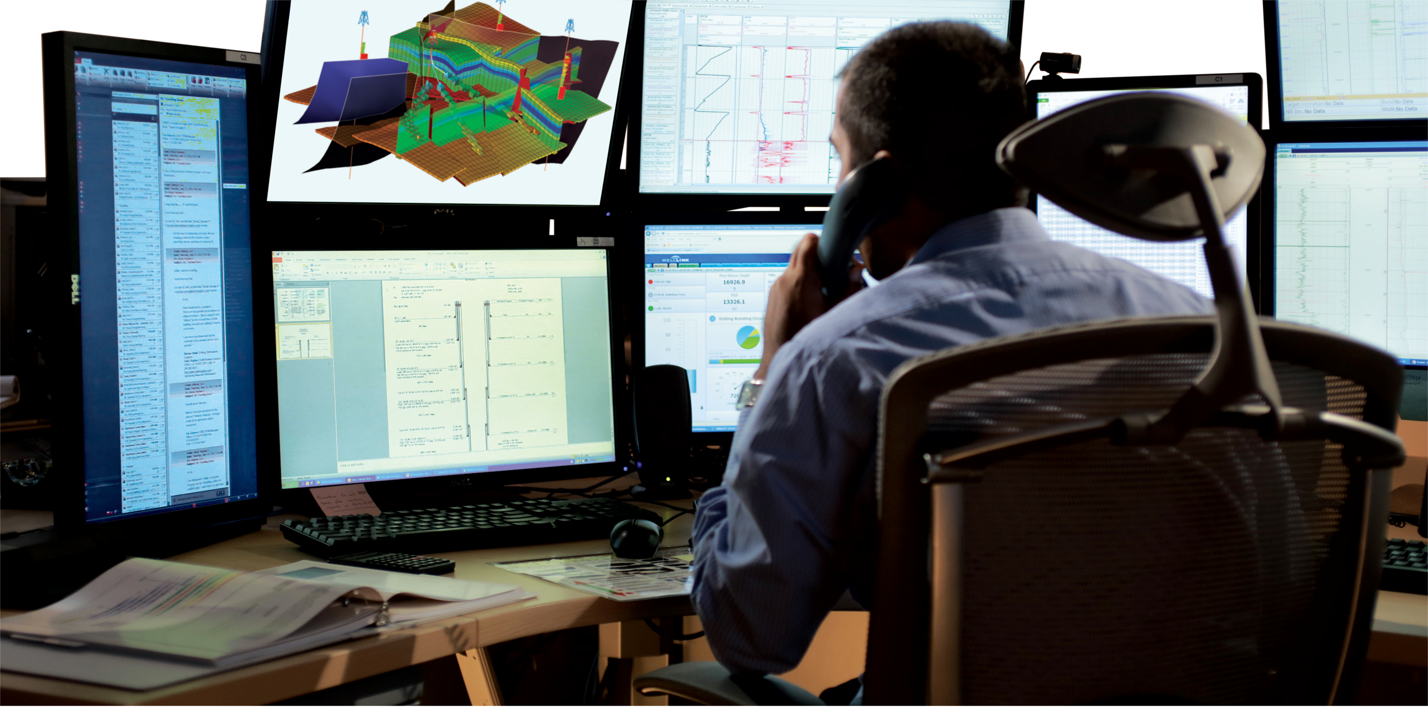 Man looking at several geoscience computer screens.