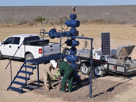 Photo of Baker Hughes engineers in the field, setting up a FlowSuite flowback solution.