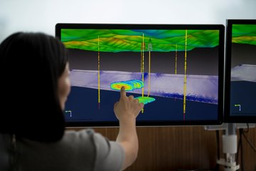 a woman analyzing seismic data on a touchscreen