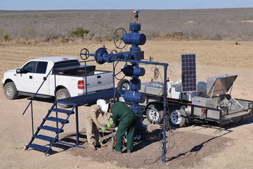 Photo of Baker Hughes engineers in the field, setting up a FlowSuite flowback solution.