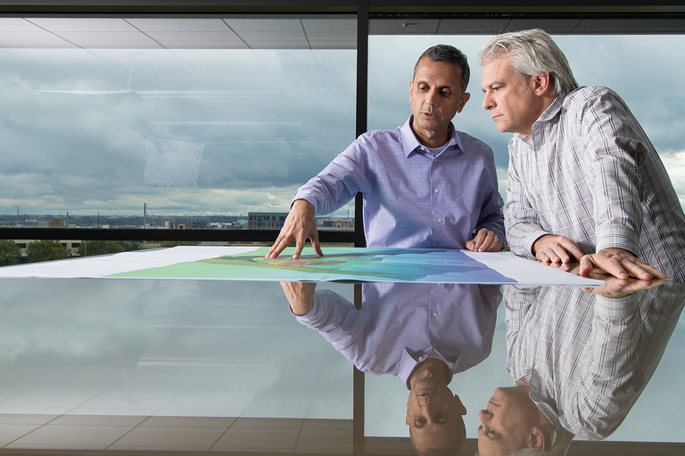 Two male colleagues from Oklahoma center collaborating on work